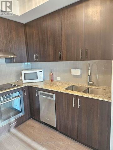 Toronto (Agincourt South-Malvern West) condo for rent - A kitchen with brown cabinets and a white microwave.