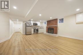 Toronto (Tam O'shanter-Sullivan) apartment for rent - A spacious living room with a fireplace and a kitchen area in the background.