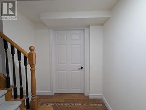 Vaughan (Crestwood-Springfarm-Yorkhill) apartment for rent - A white door is in a hallway with a wooden banister.