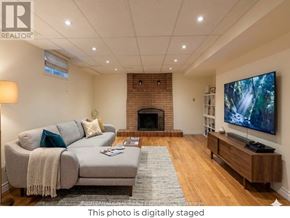 Vaughan (Crestwood-Springfarm-Yorkhill) apartment for rent - A living room with a grey couch, a fireplace, and a television.