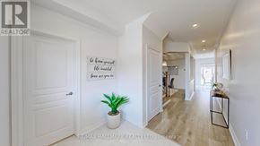 Georgina (Keswick South) apartment for rent - A hallway with a plant and a sign that says "Be kind to yourself, be kind to others".