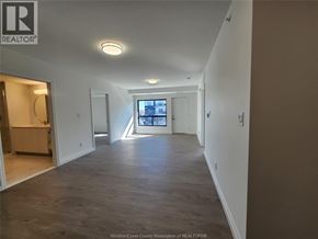 Windsor condo for rent - A spacious room with a large window and a view of the city.