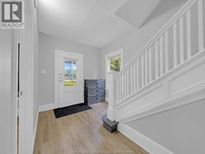 Windsor duplex for rent - A white interior with a wooden staircase and a doorway leading to another room.