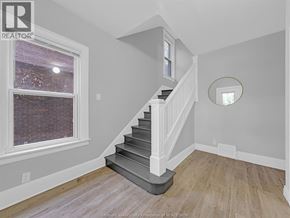 Windsor duplex for rent - A staircase in a house with a window and a mirror on the wall.