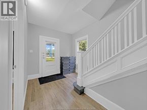 Windsor duplex for rent - A white interior with a wooden staircase and a doorway leading to another room.