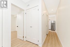 Hamilton (Stinson) multi-family for rent - A hallway with white walls and wooden floors leading to a trash bin.