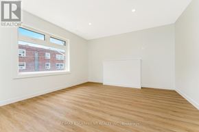 Hamilton (Stinson) multi-family for rent - A room with wooden flooring and a large window overlooking a building.