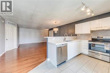 Burlington condo for rent - A kitchen with white cabinets and a wooden floor.