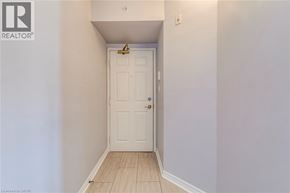 Burlington condo for rent - A white door is in a hallway with wood flooring.