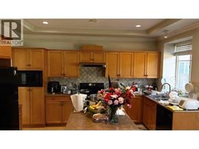 Richmond apartment for rent - A kitchen with wooden cabinets and a black fridge.
