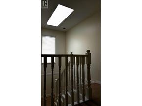 Richmond apartment for rent - A staircase with a wooden banister and a skylight above.