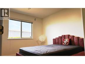 Richmond apartment for rent - A bedroom with a red bed and a window.
