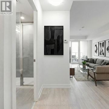 Toronto (Banbury-Don Mills) condo for rent - A modern living room with a glass door and a large abstract painting on the wall.