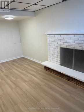 Bradford West Gwillimbury (Bradford) apartment for rent - A room with a fireplace and wooden flooring.