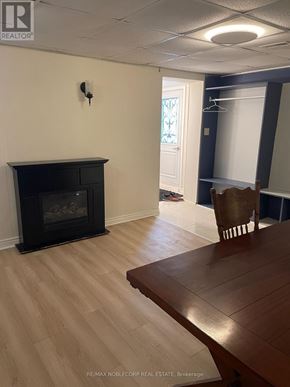 Bradford West Gwillimbury (Bradford) apartment for rent - A room with a fireplace and a wooden table.