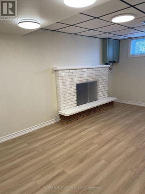 Bradford West Gwillimbury (Bradford) apartment for rent - A room with a white brick fireplace and wooden flooring.