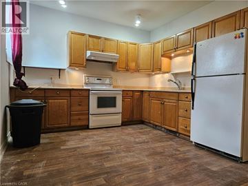 Hamilton apartment for rent - A kitchen with wooden cabinets and a white refrigerator.