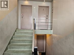 Hamilton apartment for rent - A staircase with a green carpet and a metal railing.