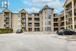 Burlington (Tansley) condo for rent - A black car is parked in the lot of a multi-story apartment building.