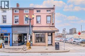 Hamilton apartment for rent - A street view with a cafe and a realtor sign.
