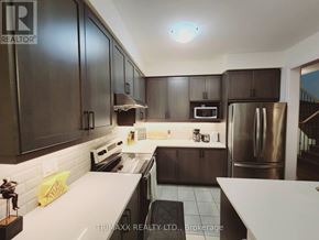 Thorold (Hurricane/Merrittville) apartment for rent - A kitchen with dark brown cabinets and stainless steel appliances.