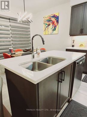 Thorold (Hurricane/Merrittville) apartment for rent - A modern kitchen with a white sink and black cabinets.