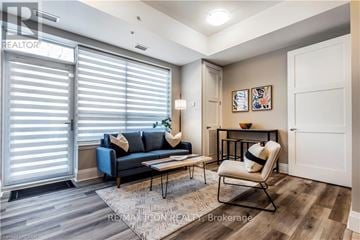 Guelph (St. Patrick's Ward) condo for rent - A living room with a blue couch and a chair.