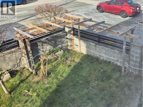 Burnaby apartment for rent - A red car is parked on the street behind a construction site.