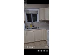 Burnaby apartment for rent - A kitchen with beige cabinets and a window above the sink.