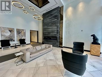 Ottawa condo for rent - A living room with a grey sofa and a black chair.