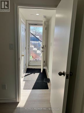 Toronto (Humber Summit) apartment for rent - A hallway with a black mat on the floor leading to a door.