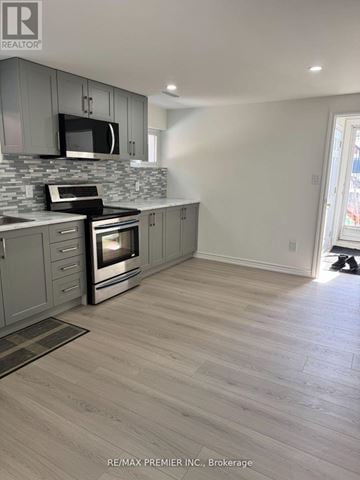 Toronto (Humber Summit) apartment for rent - A kitchen with a grey cabinet and a black microwave.