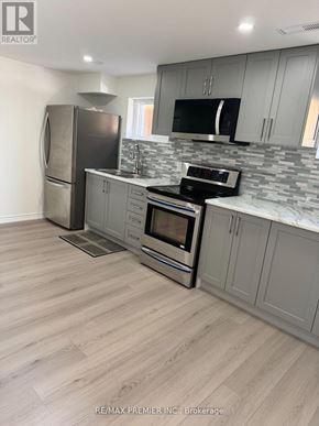 Toronto (Humber Summit) apartment for rent - A kitchen with a refrigerator, microwave, oven, and sink.