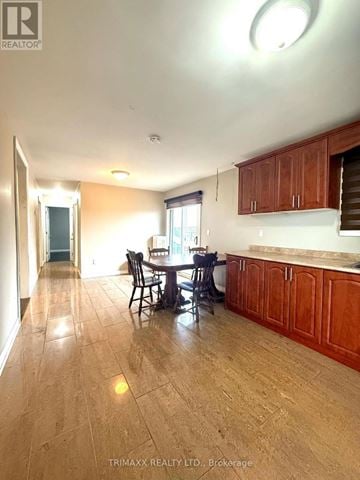 Melancthon townhouse for rent - A kitchen with wooden cabinets and a dining table.
