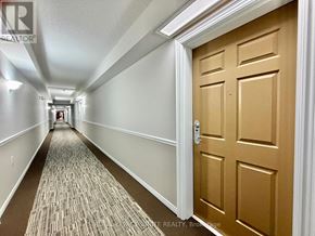 Clarington (Bowmanville) condo for rent - A hallway with a carpeted floor and a brown door.