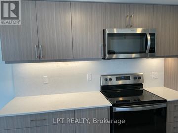 Barrie (Little Lake) condo for rent - A kitchen with a stove top oven and microwave above it.