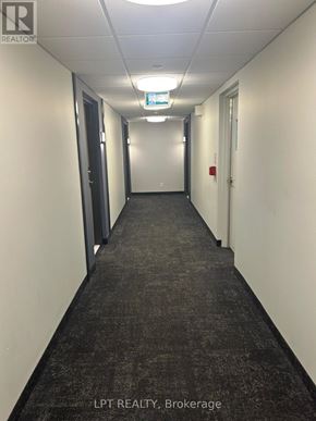 Barrie (Little Lake) condo for rent - A long hallway with doors on both sides and a carpet on the floor.
