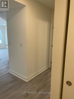Barrie (Little Lake) condo for rent - A hallway with a door on the right and a light switch on the wall.