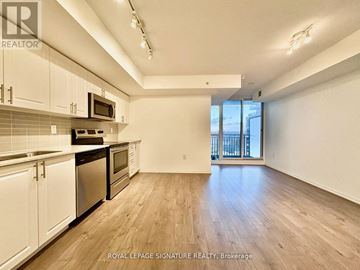 Toronto (Yorkdale-Glen Park) condo for rent - A kitchen with white cabinets and a black counter top.