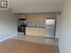 Hamilton condo for rent - A kitchen with wooden cabinets and a refrigerator.