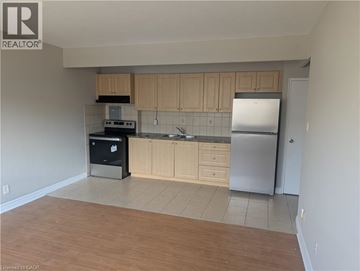 Hamilton condo for rent - A kitchen with wooden cabinets and a refrigerator.