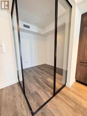 Toronto (Centennial Scarborough) condo for rent - A room with a wooden floor and a glass door.