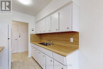 Richmond Hill (Harding) multi-family for rent - A kitchen with white cabinets and a wooden countertop.