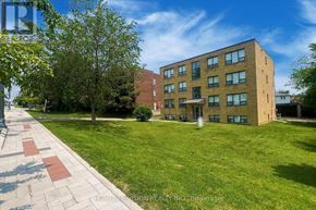 Richmond Hill (Harding) multi-family for rent - A brick building with a green lawn in front.