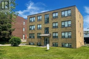 Richmond Hill (Harding) multi-family for rent - A building with a grassy area in front and a clear blue sky above.