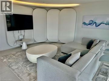 Burlington condo for rent - A modern living room with a grey sofa and a white coffee table.