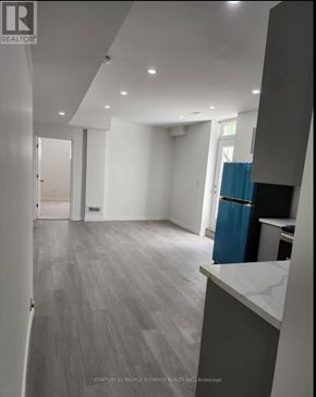 Waterloo apartment for rent - A spacious room with a blue trash bin and grey flooring.