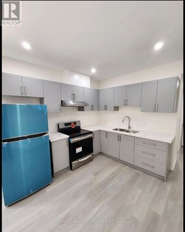 Waterloo apartment for rent - A blue refrigerator is in a kitchen with white cabinets and a sink.