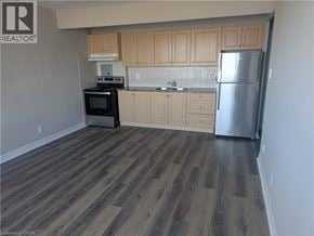 Hamilton condo for rent - A kitchen with wooden cabinets and a refrigerator.