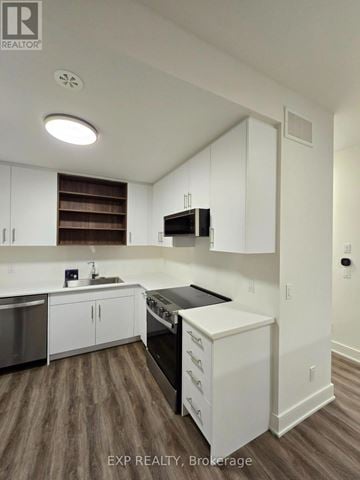 St. Catharines (Oakdale) townhouse for rent - A kitchen with white cabinets and a wooden floor.